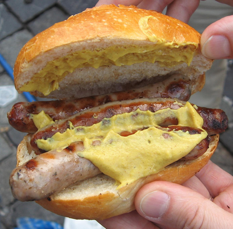 A bratwurst sandwich from a sidewalk stand.